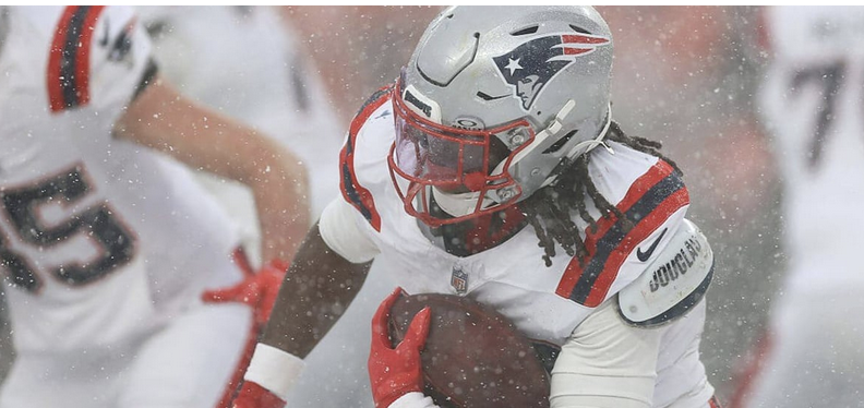 Rhamondre Stevenson running with the football