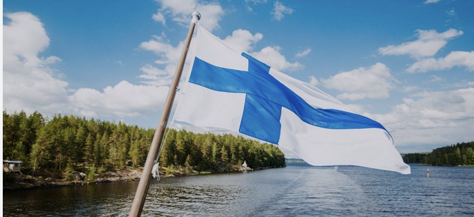 Finland flag and landscape in background