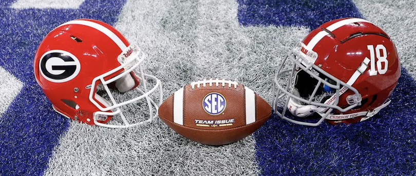 Helmets for the UGA and Alabama college football teams on field with football