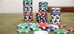 Casino chips all different colors, mostly stacked