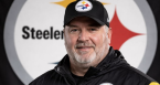 Mike McCarthy in front of a Steelers team logo
