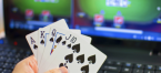 Poker cards in front of laptop with online poker site