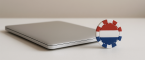 Closed laptop and a poker chip from The Netherlands